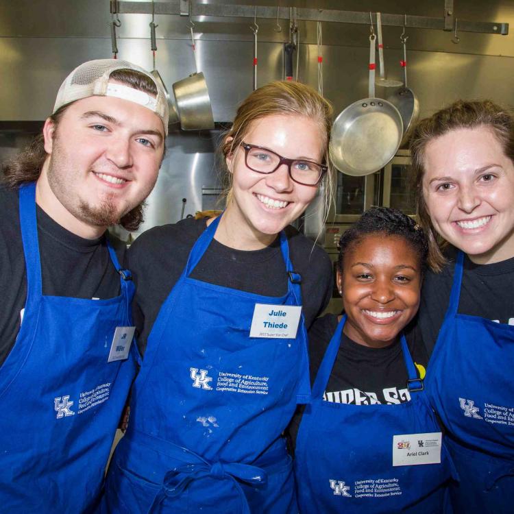   4 people in blue UK CES aprons